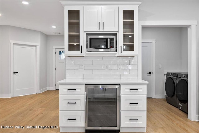 26 Debbie Dr, Athens, NY 12015 - kitchen featuring independent washer and dryer, stainless steel microwave, light countertops, wine cooler, and light wood finished floors