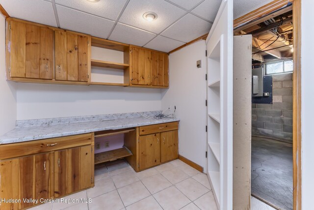 94 Tammany St, Kingston, NY 12401 - kitchen with open shelves, brown cabinetry, light tile patterned flooring, a paneled ceiling, and baseboards