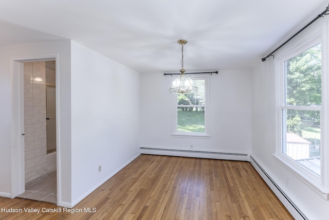 94 Tammany St, Kingston, NY 12401 - empty room featuring a baseboard heating unit, a chandelier, and light wood-type flooring