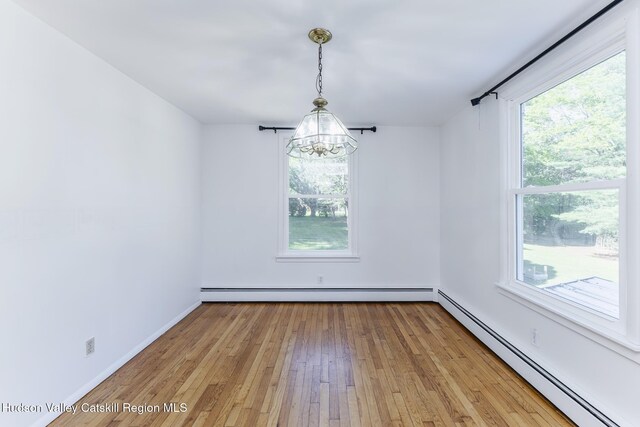 94 Tammany St, Kingston, NY 12401 - empty room featuring a baseboard radiator, a chandelier, light wood-style flooring, and baseboards