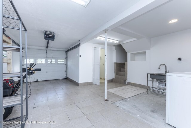 94 Tammany St, Kingston, NY 12401 - garage with washer / clothes dryer, a sink, baseboards, and a garage door opener