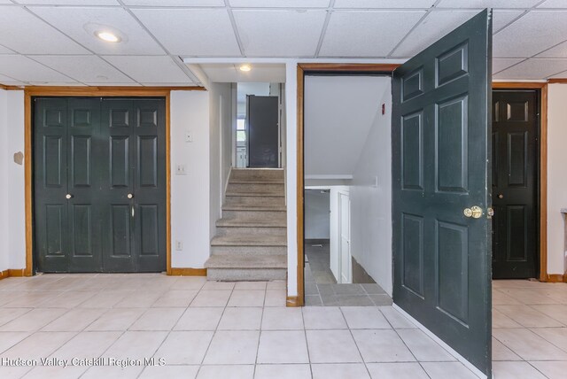 94 Tammany St, Kingston, NY 12401 - entryway with a drop ceiling, stairs, light tile patterned flooring, and baseboards