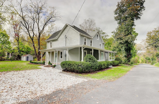 view of home's exterior featuring a storage shed, a lawn, and a porch