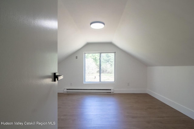 additional living space with baseboards, vaulted ceiling, baseboard heating, and wood finished floors