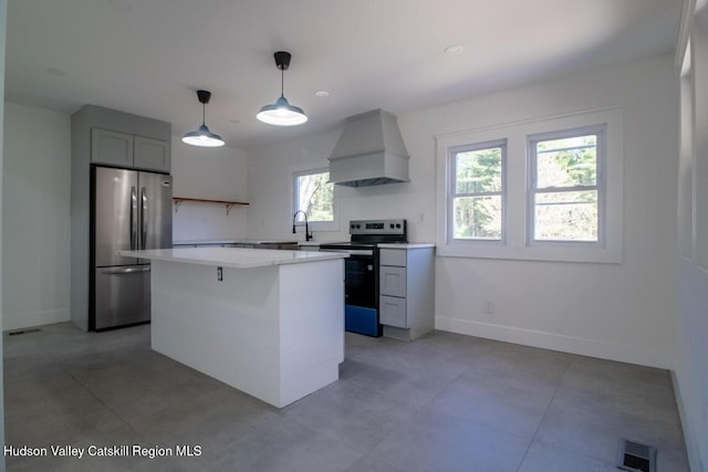 kitchen featuring visible vents, appliances with stainless steel finishes, light countertops, baseboards, and custom range hood