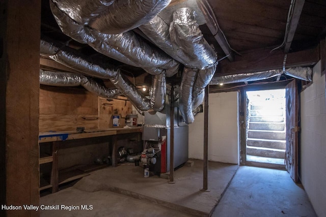 unfinished basement featuring heating unit and a workshop area