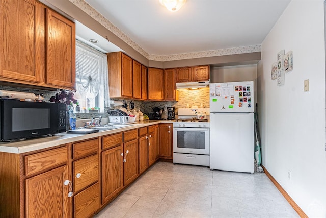 14 Montross St, Saugerties, NY 12477 - kitchen featuring white appliances, under cabinet range hood, backsplash, brown cabinets, and light countertops