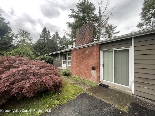 18 Marys Ave, Saugerties, NY 12477 - view of side of property with a chimney and brick siding