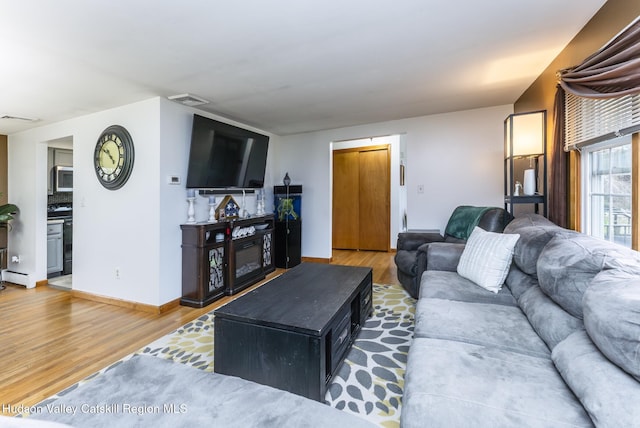 living room featuring baseboards, wood finished floors, and visible vents