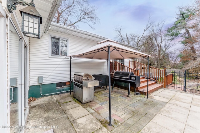 view of patio / terrace with fence, a gazebo, area for grilling, and a detached carport