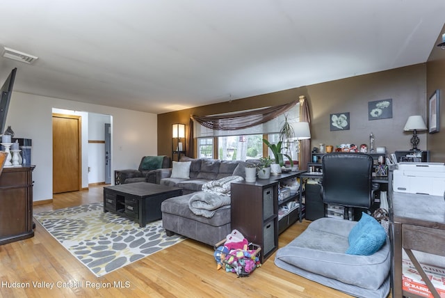 living area with wood finished floors and visible vents