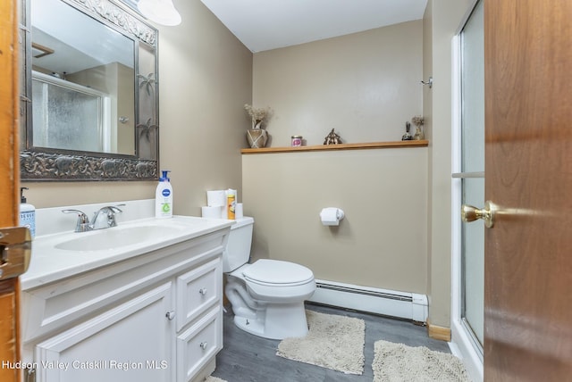 full bath with baseboard heating, a shower stall, vanity, and wood finished floors