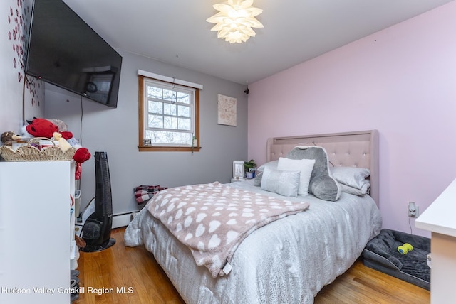bedroom featuring a baseboard radiator and wood finished floors