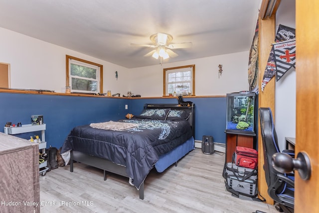 bedroom featuring a baseboard radiator, wood finished floors, and ceiling fan