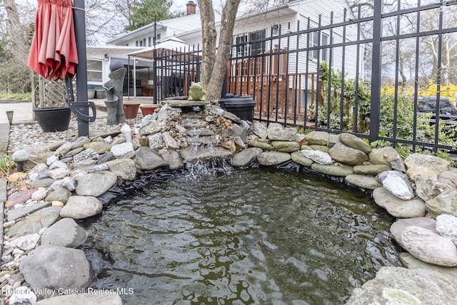 view of yard featuring fence and a garden pond