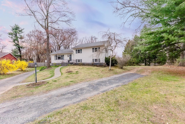 split level home with fence, a front lawn, and driveway