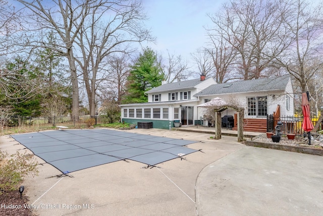 view of pool featuring a sunroom, fence, a patio area, and a fenced in pool