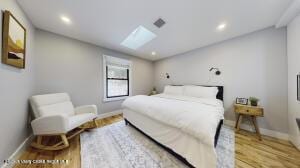 bedroom featuring light hardwood / wood-style floors and a skylight