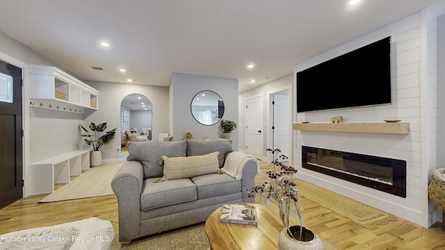 living room with wood-type flooring and a fireplace