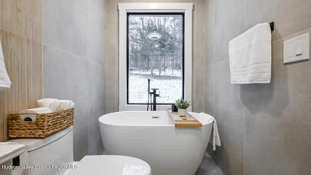 bathroom featuring a washtub and toilet