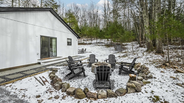 snow covered patio featuring a fire pit