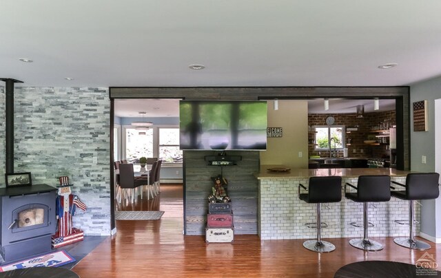 12658 Rte 23, Ashland, NY 12407 - bar featuring a wood stove, wood finished floors, and a baseboard radiator