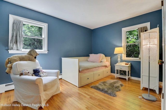 512 Watson Woods Rd, Lake Hill, NY 12448 - bedroom with multiple windows, wood finished floors, and a baseboard heating unit