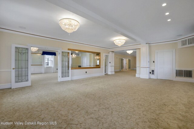 unfurnished living room featuring a notable chandelier, crown molding, visible vents, and carpet flooring