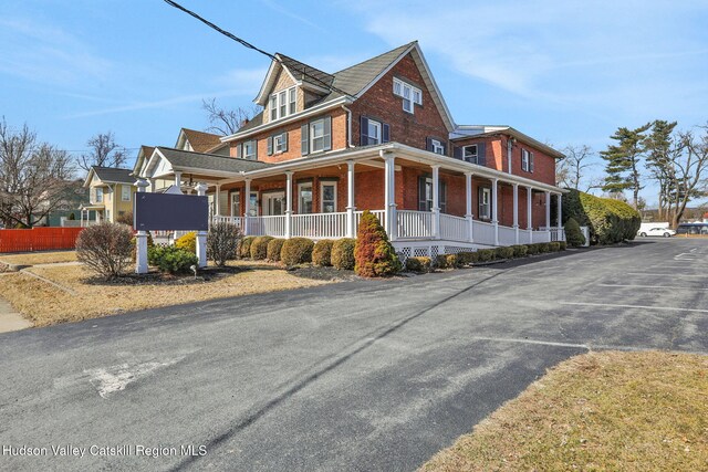 view of front of house with covered porch and brick siding