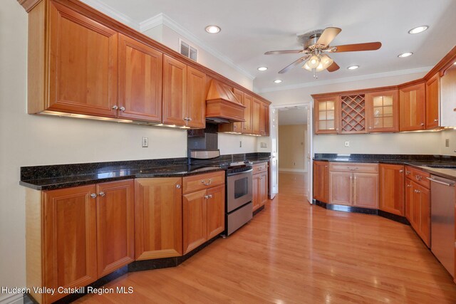 kitchen featuring a ceiling fan, premium range hood, visible vents, light wood-style flooring, and appliances with stainless steel finishes