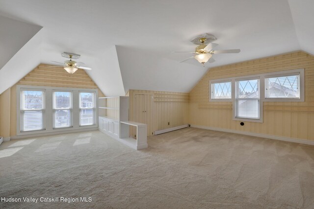 additional living space with carpet flooring, ceiling fan, lofted ceiling, and baseboard heating