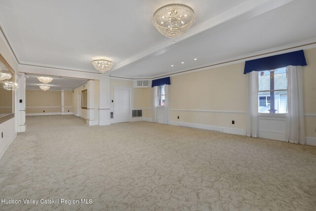 carpeted spare room featuring crown molding, beamed ceiling, a notable chandelier, and visible vents