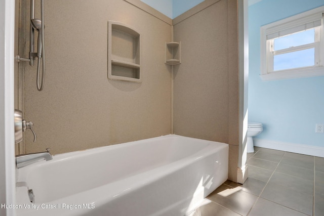 bathroom featuring baseboards, toilet, tile patterned flooring, and bathing tub / shower combination