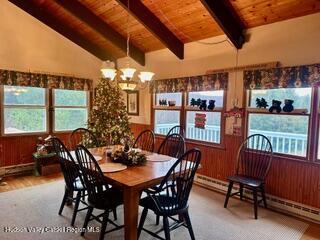 212 S St, Windham, NY 12496 - dining area featuring a chandelier, wood ceiling, plenty of natural light, a baseboard heating unit, and wood walls