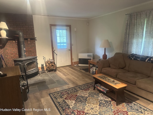 212 S St, Windham, NY 12496 - living area with wood finished floors, a wood stove, crown molding, baseboards, and heating unit
