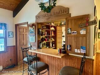 212 S St, Windham, NY 12496 - indoor dry bar with wood finished floors, a wainscoted wall, and wooden walls