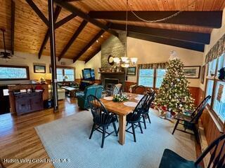 212 S St, Windham, NY 12496 - dining space featuring wood ceiling with exposed beams, plenty of natural light, a fireplace, wood finished floors, and a chandelier