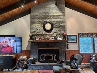 212 S St, Windham, NY 12496 - living room with wood ceiling, wood finished floors, a wainscoted wall, a baseboard heating unit, and a large fireplace