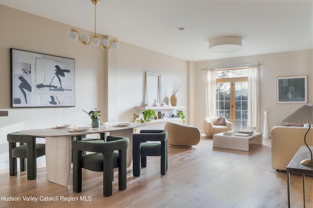 dining space with light wood-type flooring and french doors