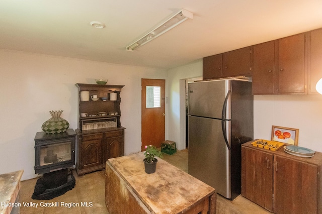 73 Cauterskill Ave, Catskill, NY 12414 - kitchen featuring freestanding refrigerator, a wood stove, and a center island