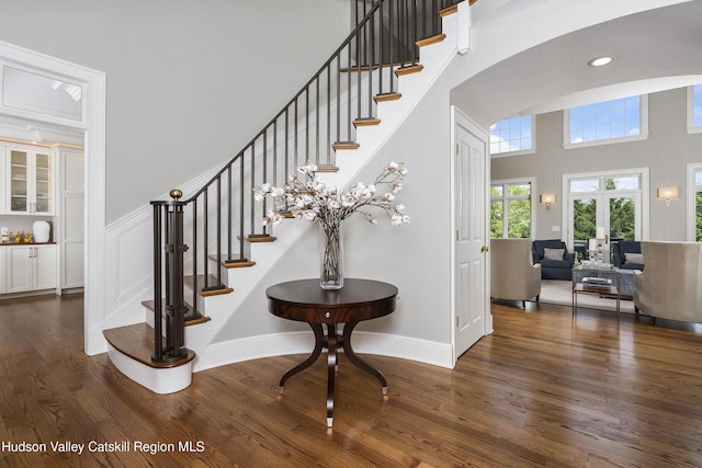 1 Stoneridge Dr, Loudonville, NY 12211 - staircase with wood finished floors, a towering ceiling, arched walkways, and recessed lighting