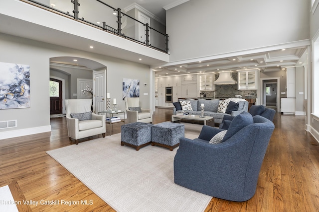 1 Stoneridge Dr, Loudonville, NY 12211 - living room featuring arched walkways, ornamental molding, wood finished floors, recessed lighting, and a towering ceiling