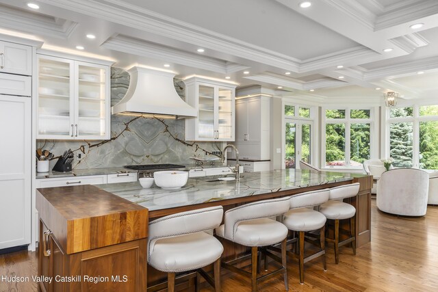 1 Stoneridge Dr, Loudonville, NY 12211 - kitchen with custom exhaust hood, crown molding, dark stone counters, backsplash, and wood finished floors