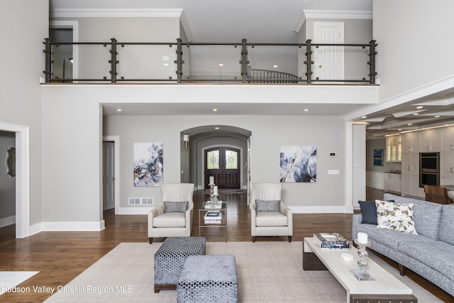 1 Stoneridge Dr, Loudonville, NY 12211 - living area featuring wood finished floors, ornamental molding, a high ceiling, arched walkways, and french doors