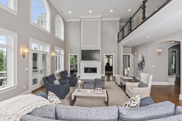 1 Stoneridge Dr, Loudonville, NY 12211 - living area featuring a towering ceiling, arched walkways, crown molding, wood finished floors, and recessed lighting