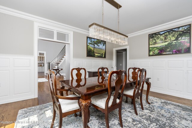 1 Stoneridge Dr, Loudonville, NY 12211 - dining space featuring crown molding, wood finished floors, a decorative wall, wainscoting, and stairway