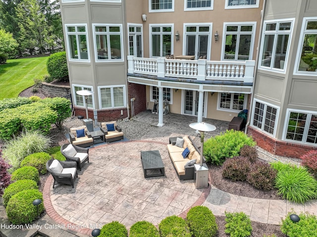 1 Stoneridge Dr, Loudonville, NY 12211 - back of property with outdoor lounge area, a patio area, brick siding, and stucco siding