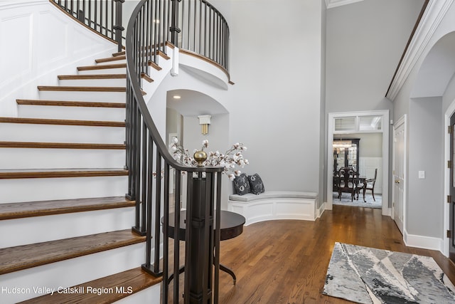 1 Stoneridge Dr, Loudonville, NY 12211 - entryway with stairs, wood finished floors, a wainscoted wall, a towering ceiling, and a decorative wall