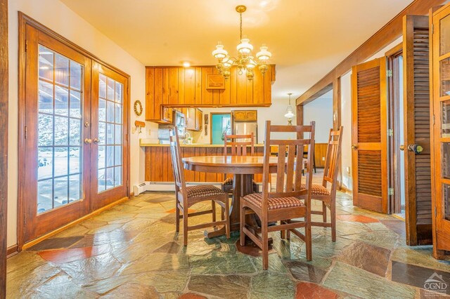 176 High Rock Rd, West Coxsackie, NY 12192 - dining space with french doors, stone flooring, and a chandelier
