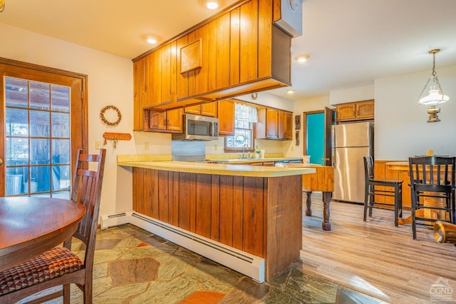 176 High Rock Rd, West Coxsackie, NY 12192 - kitchen with stainless steel appliances, a baseboard radiator, light countertops, brown cabinetry, and a peninsula